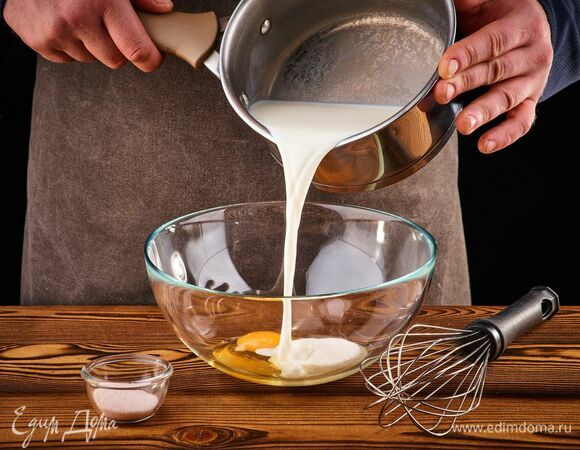Разогрейте молоко примерно до 40°C. В глубокую чашу разбейте яйцо, добавьте сахар и соль. Перемешайте венчиком. Влейте тонкой струйкой теплое молоко.
