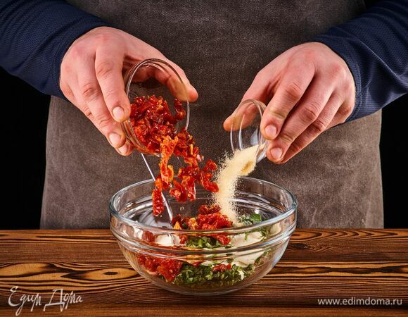 Добавьте сушеный чеснок, мелко нарезанные вяленые томаты и рубленый базилик. Перемешайте.