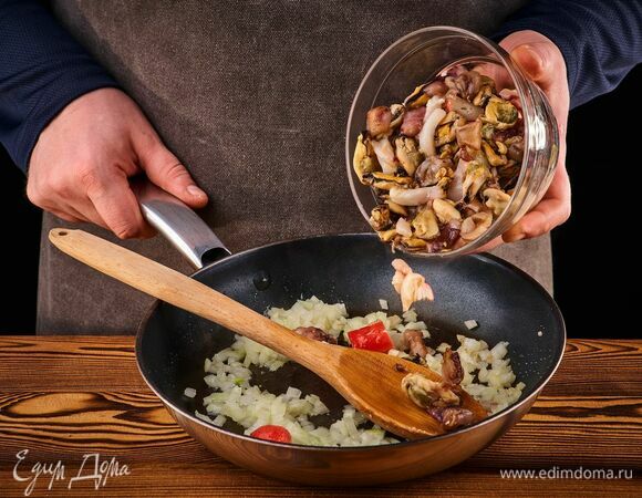 Лук почистите и мелко порубите. Обжарьте на сковороде с оливковым маслом. Добавьте микс из морепродуктов. Посолите, поперчите. Готовьте морепродукты столько, сколько указано на упаковке.