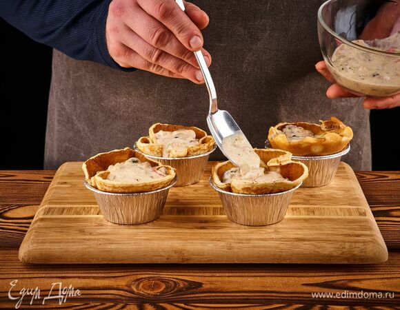 Наполните корзиночки из блинов сырной начинкой и перед подачей украсьте рубленым укропом.