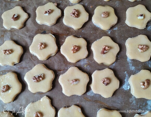 Смазать печенье желтком и положить кусочек грецкого ореха. Выпекать при температуре 190°C 10 минут.