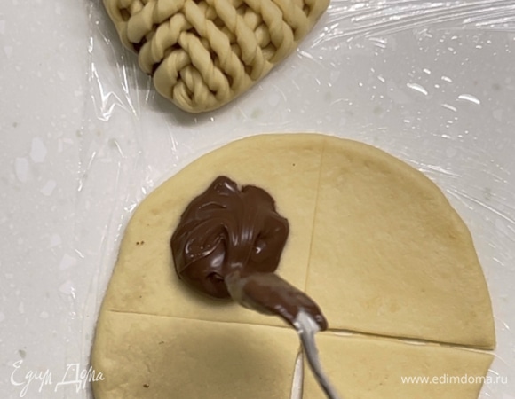 Далее выложить тесто на стол. Сформировать булочки. Для начинки можно использовать любимый джем, нутеллу, орехи. Из кусочка теста раскатать круг. И поделить на 4 части. Но! Разрезать только нижнюю правую четверть.