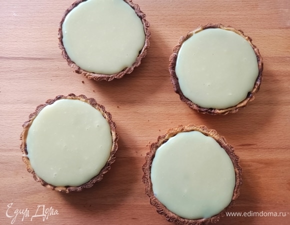 В сотейник с толстым дном влить 40 мл сливок, добавить измельченный белый шоколад. Поставить на огонь и растопить. Сверху шоколадного слоя выложить белый шоколад.