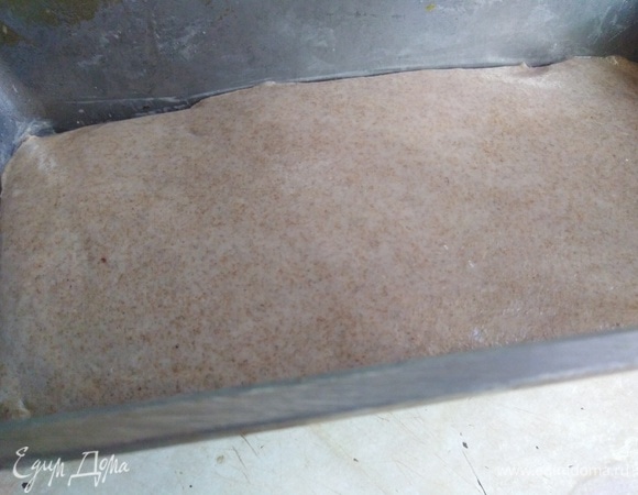 Перекладываем тесто в смазанную форму для выпечки. Уплотняем, разравниваем. Верхушку разглаживаем влажной рукой или силиконовой лопаткой.