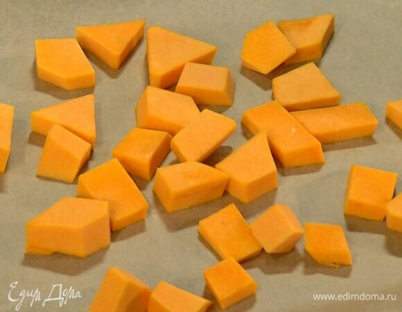Тыкву почистить, нарезать небольшими кубиками и выложить на противень, выстеленный бумагой для выпечки.