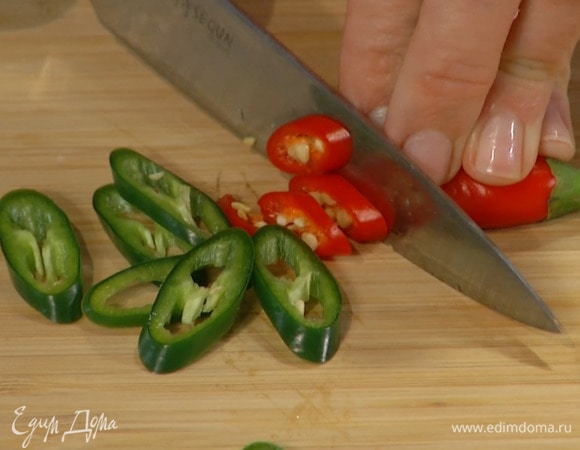 Весь перец чили нарезать тонкими колечками и отправить к чесноку, добавить помидоры в собственном соку, немного посолить, перемешать и прогреть.