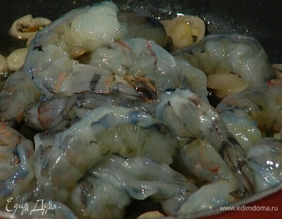 Весь перец чили нарезать колечками и отправить к луку с чесноком, все посолить, затем добавить креветки.