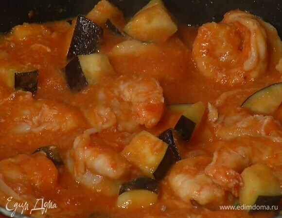 Баклажан нарезать небольшими кубиками, выложить в сковороду с креветками и обжаривать, пока креветки не поменяют цвет, затем добавить измельченные помидоры, все перемешать и прогреть.