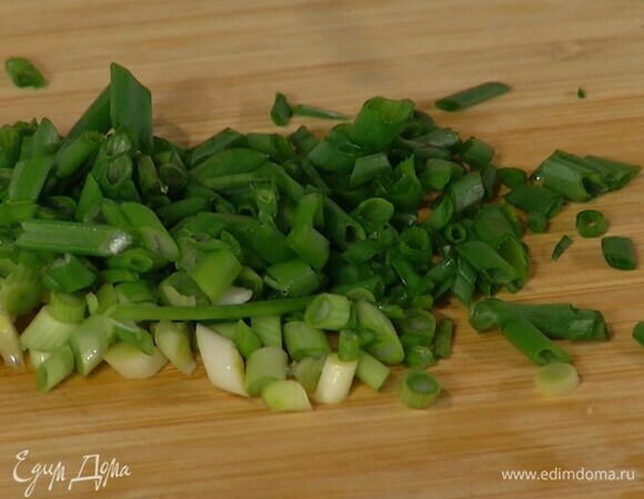 Зеленый лук тонко порезать наискосок и добавить в сковороду.