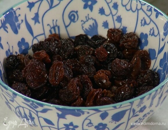 Изюм замочить в кипятке и дать постоять, затем, слив жидкость, отжать.