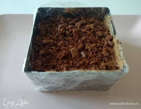 Берем форму с основой, сверху выкладываем шоколадный мусс и остатки бисквита, предварительно измельчив его. Отправляем десер в холодильник на 6 часов для стабилизации.