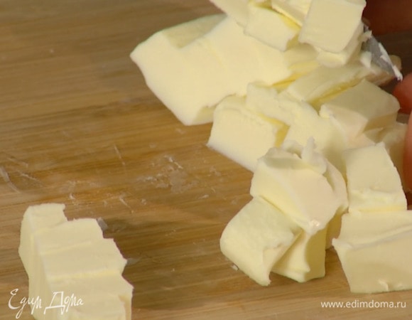 Предварительно охлажденное сливочное масло нарезать маленькими кубиками.