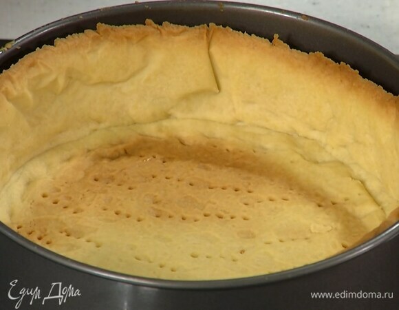 Часто наколоть тесто вилкой, застелить бумагой для выпечки, всыпать любые бобовые и отправить в разогретую духовку минут на 15–20.