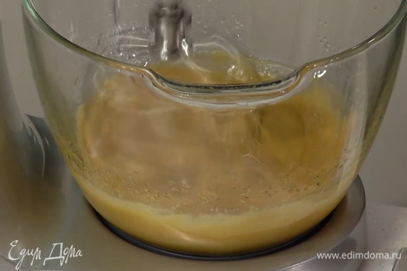 Приготовить тесто: сахар и яйца поместить в чашу комбайна и взбить, затем, продолжая взбивать, тонкой струйкой влить растительное масло и молоко.