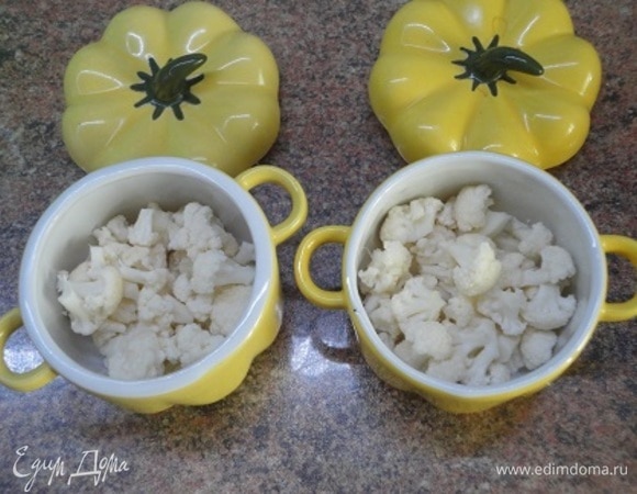 Формы для запекания смажьте сливочным маслом. Для всей нормы понадобится одна форма диаметром 20 см или 4 порционные формочки, как у меня. Кочан цветной капусты (или брокколи) разберите на мелкие соцветия и выложите в формочки.