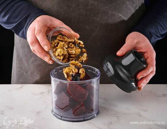 Выложите в чашу блендера отварную свеклу и грецкие орехи. Измельчите.