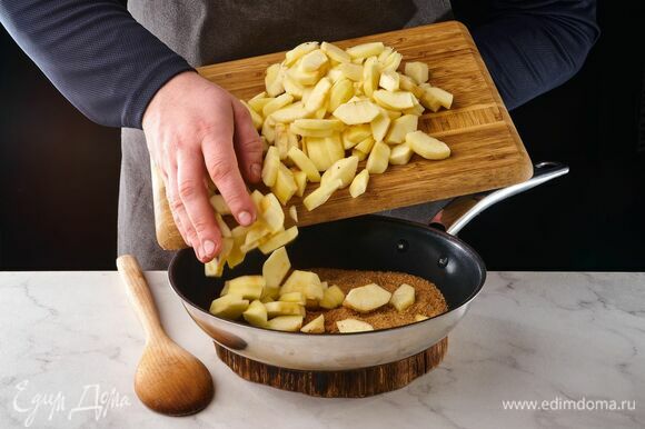 На сухую сковороду выложите коричневый сахар, корицу и яблоки. Обжаривайте, помешивая, на среднем огне примерно 5 минут.