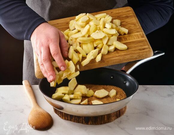 На сухую сковороду выложите коричневый сахар, корицу и яблоки. Обжаривайте, помешивая, на среднем огне примерно 5 минут.