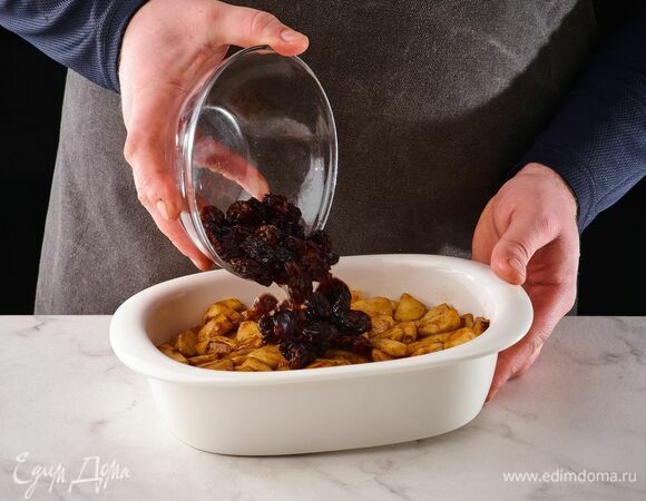 В форму для запекания выложите обжаренные яблоки и изюм.