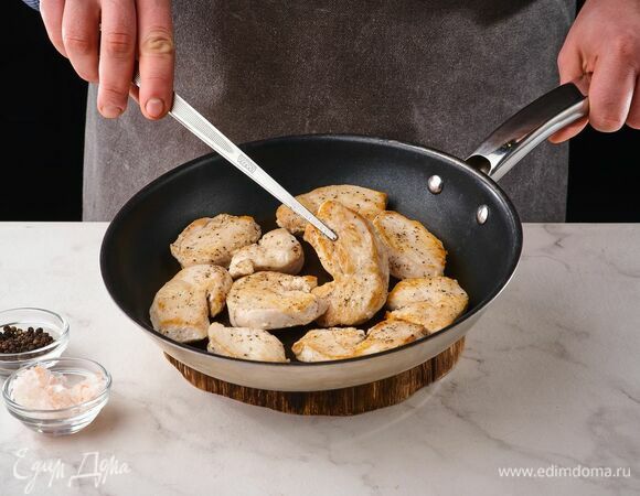 На разогретой сковороде с оливковым маслом обжарьте куриное филе до золотистого цвета. Посолите, поперчите и уберите со сковороды.