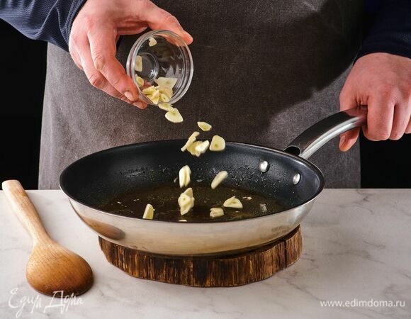 Чеснок нарежьте и обжарьте в той же сковороде.