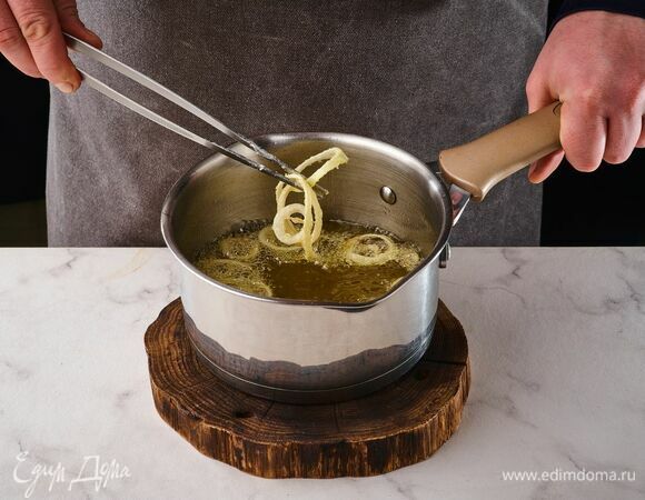 В сотейнике доведите до кипения растительное масло. Обжарьте лук небольшими порциями по 5 минут. Выложите лук на бумажное полотенце, чтобы убрать лишнее масло.