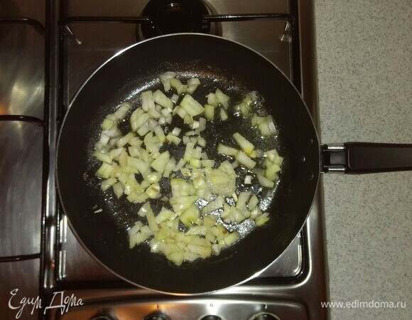 Растопить на сковороде часть сливочного масла, выложить нарезанный репчатый лук и обжарить его на среднем огне 1 минуту.