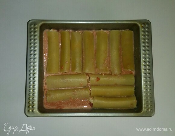 Затем начинить каннелонни смесью заранее обжаренных помидоров, репчатого лука и куриных грудок и выложить их в форму. Разогреть духовку до 190°C и поставить в нее форму на 35 минут (время приготовления зависит от вашей духовки). За 10 минут до окончания приготовления посыпать каннеллони тертым сыром и запечь до готовности.