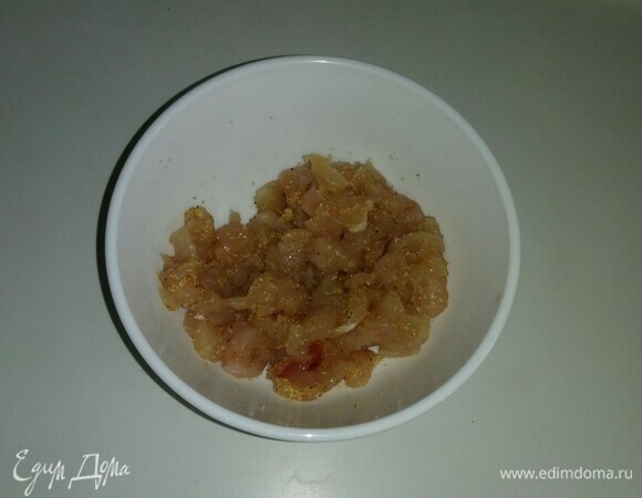 Куриное мясо нарезать мелкими кубиками, положить в пиалу и посыпать солью, черным молотым перцем и сушеным молотый чесноком. Все перемешать и убрать в холодильник на 20 минут.