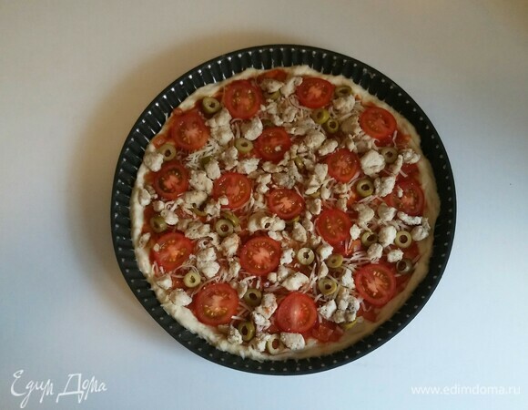 Затем на сыр выложить нарезанные оливки, помидоры черри и обжаренное нарезанное куриное мясо. Разогреть духовку до 200°C и поставить в нее противень с пиццей на 18 минут (время приготовления зависит от вашей духовки). Приятного аппетита!