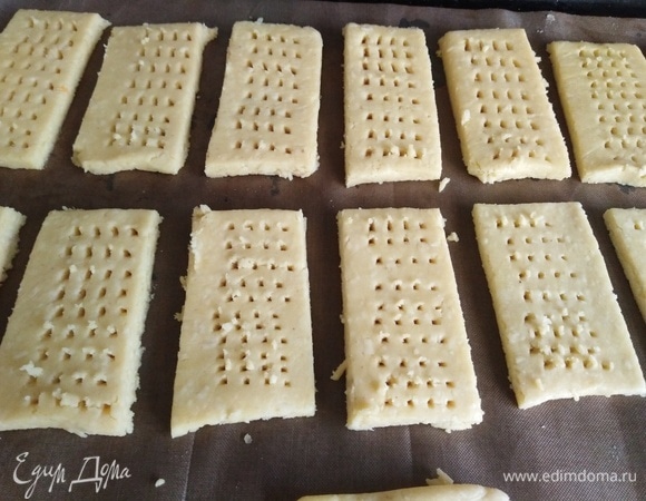 Тесто раскатать в пласт, нарезать, сделать наколы вилкой. Выложить на пекарский лист.