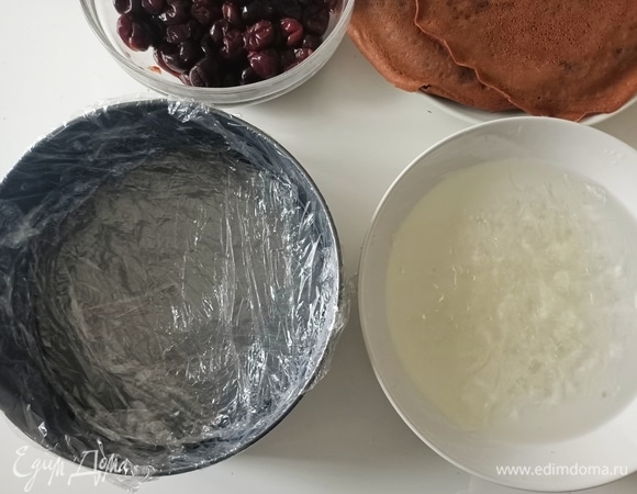 Разъемную форму застелить пищевой пленкой. Желатин замочить в холодной воде (10–15 минут).