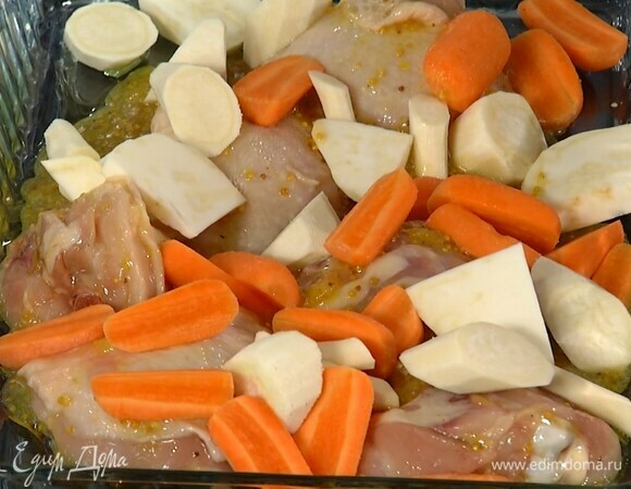 Противень полить 1 ст. ложкой оливкового масла, выложить курицу с маринадом, затем нарезанные овощи и чеснок.