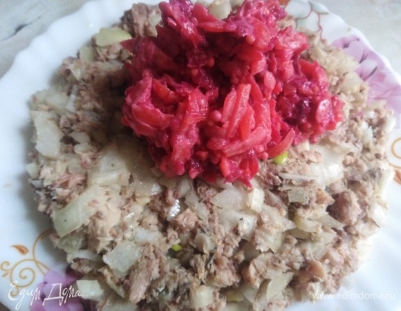 В тарелку первым слоем выложить рыбу с луком. Затем слой свеклы с морковью.