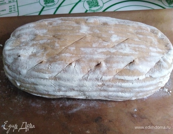 Переложить тесто на коврик. Сделать надрезы. Поставить в разогретую духовку.