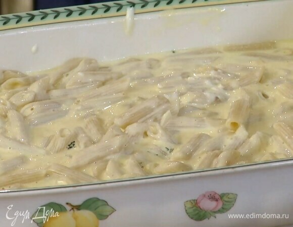 Переложить макароны в жаропрочную керамическую форму, влить 100–150 мл воды, в которой они варились, и перемешать, затем залить все сливочно-сырным соусом, добавить сметану и еще раз перемешать.