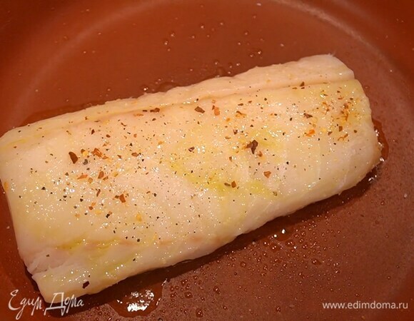 Филе трески полить оливковым маслом, посолить, посыпать черным перцем и чили, затем выложить на разогретую сковороду и жарить по 4 минуты с каждой стороны.