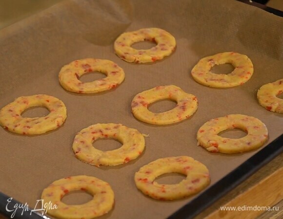 Вырезать из теста кольца и выложить их на противень, выстеленный бумагой для выпечки.