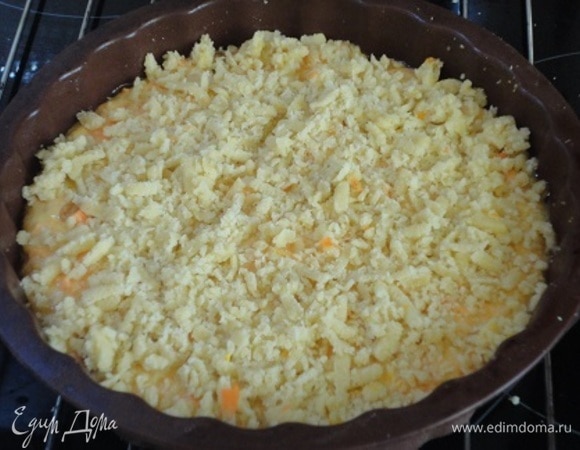 Перемешать и выложить в подготовленную форму диметром 18–20 см, не больше. Если она металлическая, дно желательно выстелить пекарской бумагой, бортики смазать маслом. Сверху натереть тесто из морозилки (так получится ровнее), но можно было сразу перетереть в крошку и хранить в холодильнике до начала выпечки. У меня красивая крошка не получилась, и я сразу же придумала вариант с морозильной камерой и теркой.