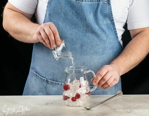 В кувшин положите лед, малину и добавьте сахарный сироп.