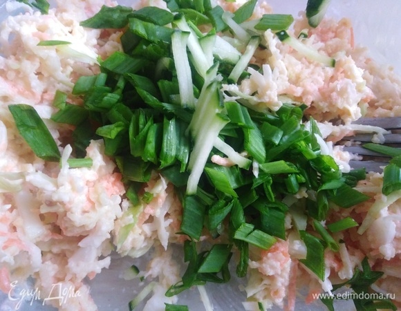 В салат добавить нарезанный тонкой соломкой огурец и измельченный зеленый лук. Посолить по вкусу.