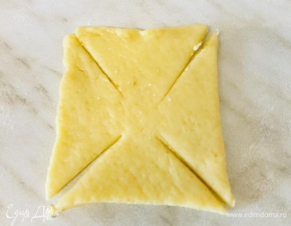 Достаньте половину теста из холодильника. На слегка посыпанном мукой листе пергамента раскатайте тесто в квадрат толщиной около 4 мм. Вырежьте ножом квадраты по 8 см, затем осторожно переложите на подготовленные противни на расстоянии примерно 2 см друг от друга. Если тесто становится слишком мягким, переложите пергамент с тестом на противень и поставьте в холодильник до застывания.