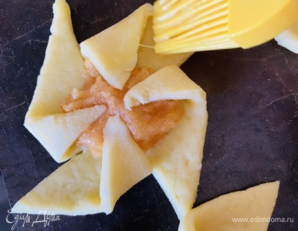 Слегка взбейте оставшееся яйцо со щепоткой соли. Кисточкой слегка смажьте верхушки печенья яичной смесью. Выпекайте в разогретой до 180°C духовке, пока края не станут золотистыми, а печенье слегка не распухнет, от 15 до 20 минут.