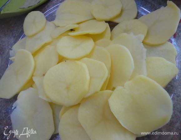 Очистите картофель и нарежьте (лучше при помощи терки-мандолины или просто тонким острым ножом) кружками толщиной не больше 2 мм. Очистите лук и нарежьте тонкими полукольцами. Можно использовать сырой, но я жарила его в растительном масле до золотистого цвета, предварительно посолив. Сухие грибы измельчите в кофемолке или ступке. Если вы решили использовать свежий чеснок, то пробейте его в блендере с растительным масло (100 мл). Включите духовку на 180°C.