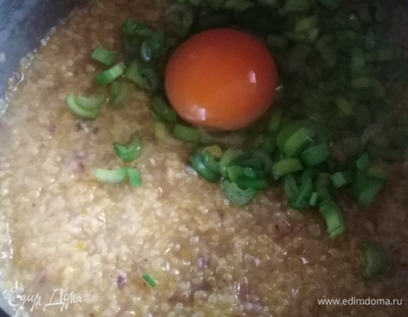 В кашу добавить зеленый лук, вбить яйцо. Усилить огонь до максимума и интенсивно перемешать. Выключить, оставить под крышкой на 15 минут.