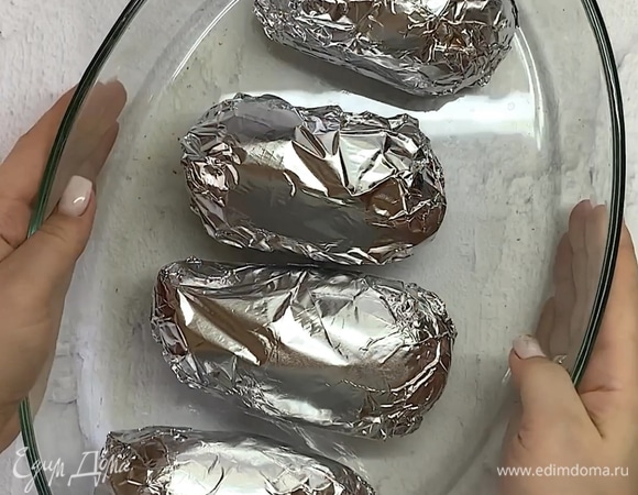 Каждую картофелину заворачиваем плотно в фольгу и ставим в духовку при 180°C на 1–2 часа в зависимости от размера.