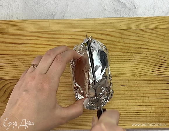 Достаем картошку и разрезаем пополам не до конца. Если картофель еще не пропекся, просто обратно ставим в духовку.