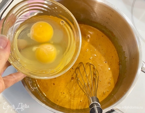 Когда масса перестанет расти в объеме, снять кастрюлю с плиты. Добавить яйца. Тщательно мешать массу венчиком, чтобы не дать яйцам свернуться.
