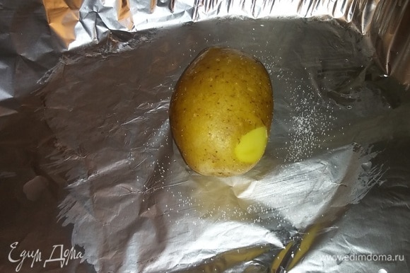Подготовить фольгу, в которой будет запекаться картофель. Смазать фольгу растительным маслом, положить картофель, предварительно наколов его в нескольких местах вилкой, и посыпать его солью. Сделать так для каждой картофелины.