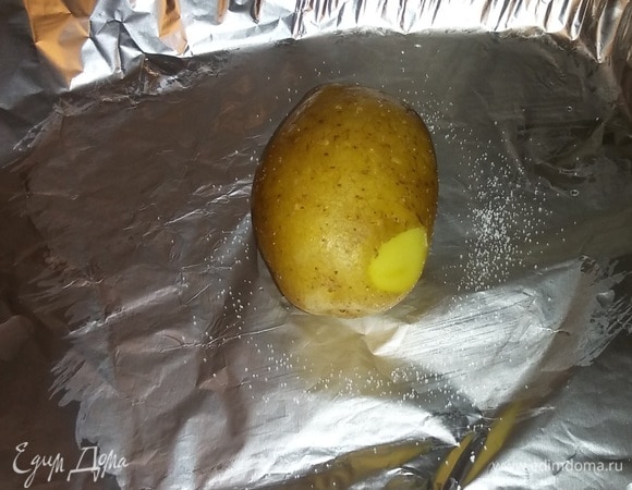 Подготовить фольгу, в которой будет запекаться картофель. Смазать фольгу растительным маслом, положить картофель, предварительно наколов его в нескольких местах вилкой, и посыпать его солью. Сделать так для каждой картофелины.